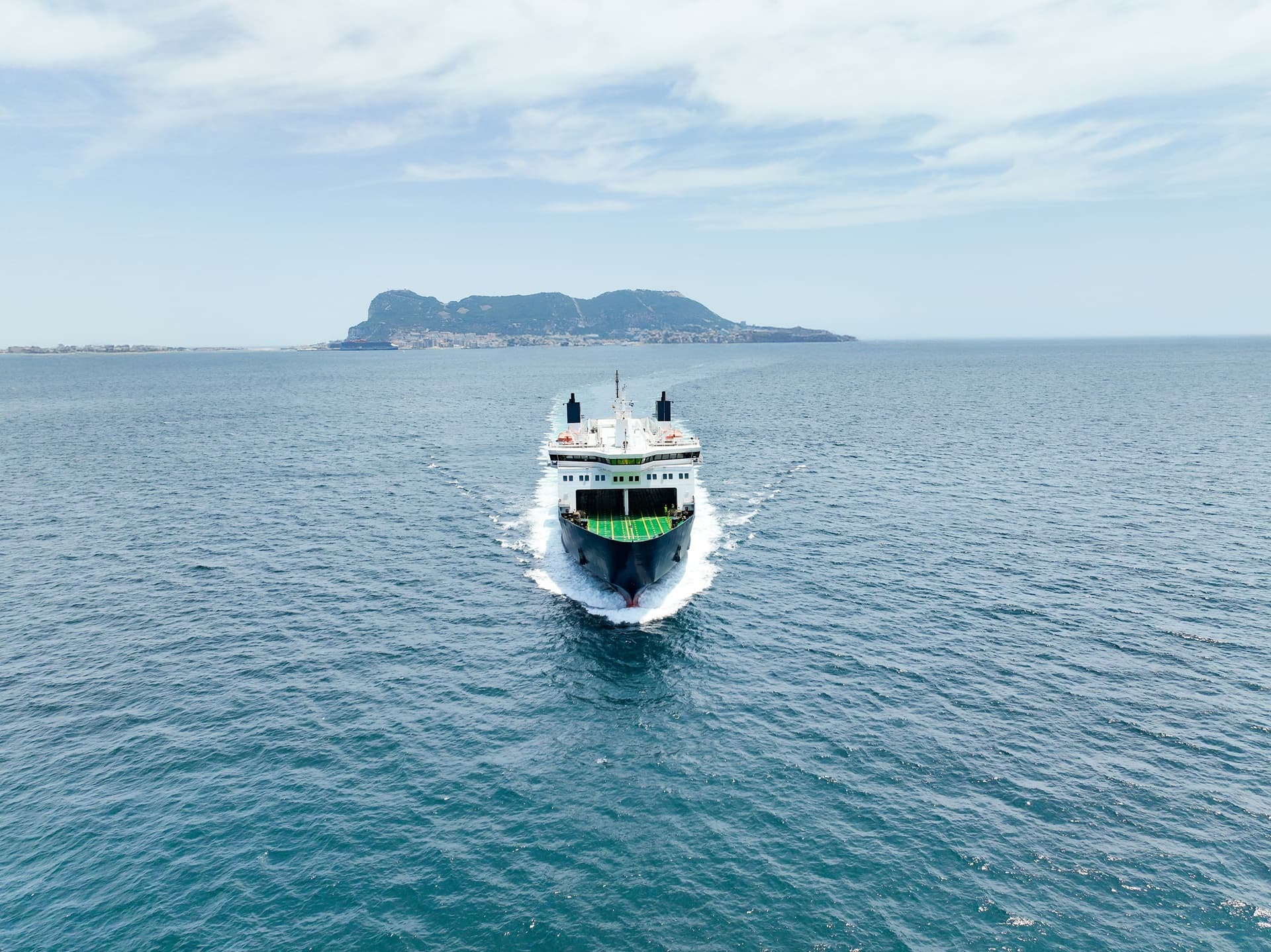 Featured news article - DFDS vessel on full sea, with land in the background seen