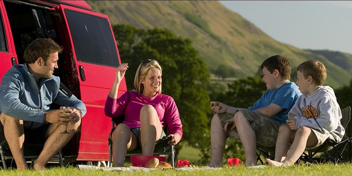 Family of four sitting on camping chairs in the Lake District