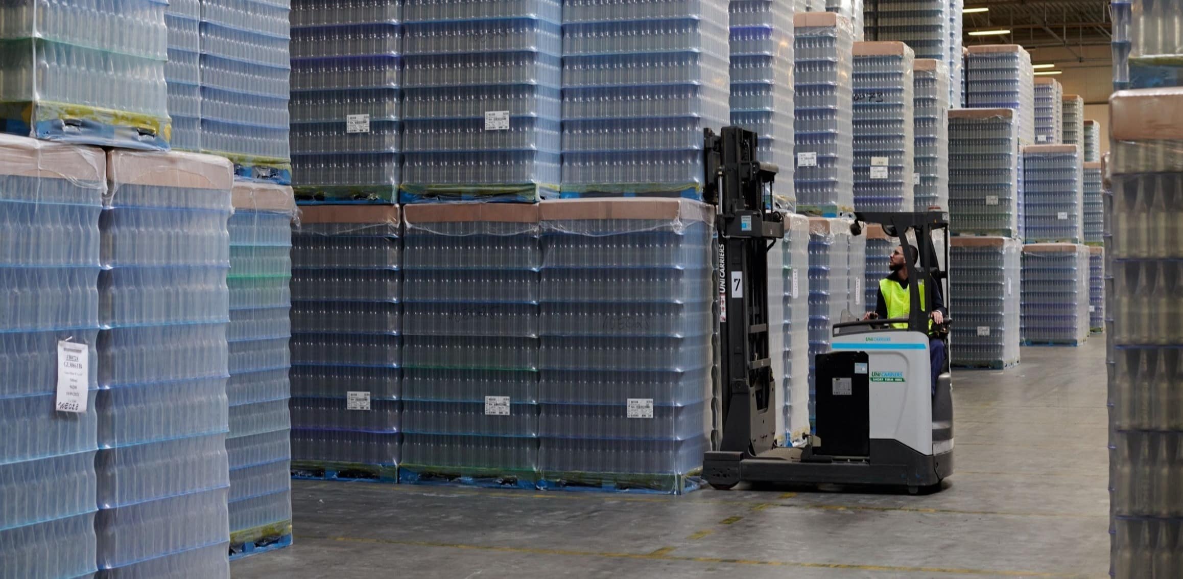 A DFDS employee picks up a pallet with packed bottles with a forklift