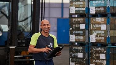 A DFDS Logistics employee scanning a checklist inside a warehouse