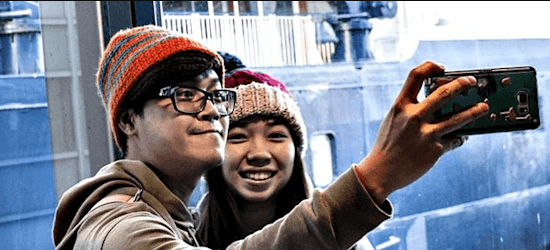 Asian tourists taking a selfie in front of DFDS vessel Pearl Seaways