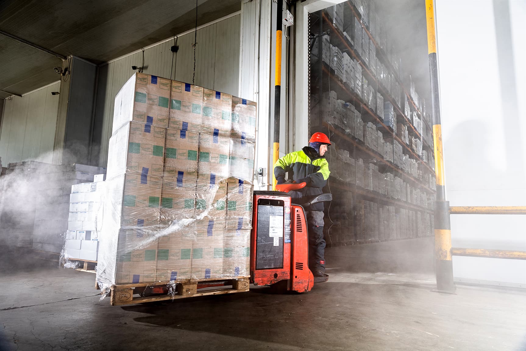 A DFDS cold chain employee drives goods into a cold storage room