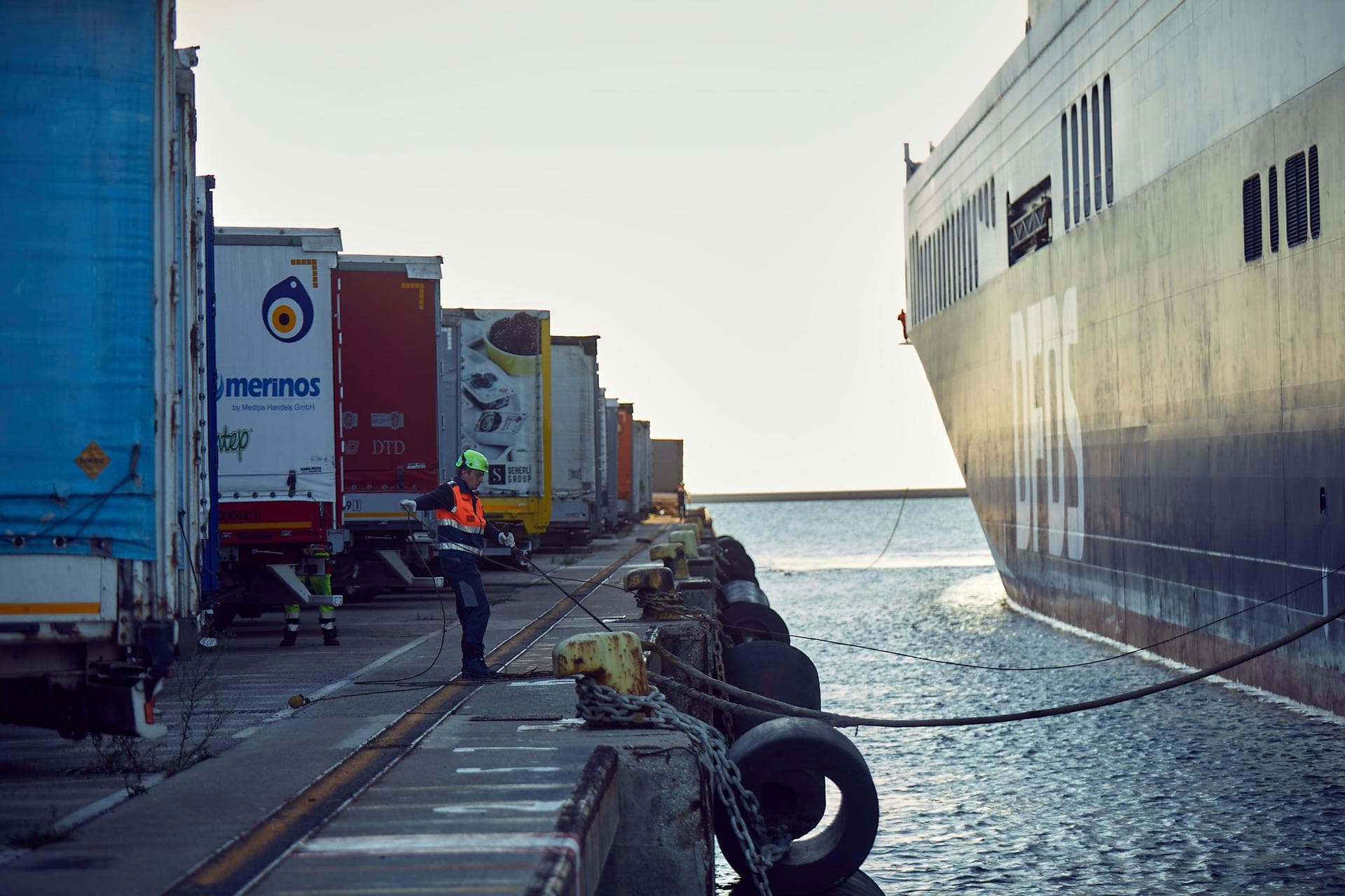 A man pulling the dock rope while the DFDS ship is arriving at the port in Trieste