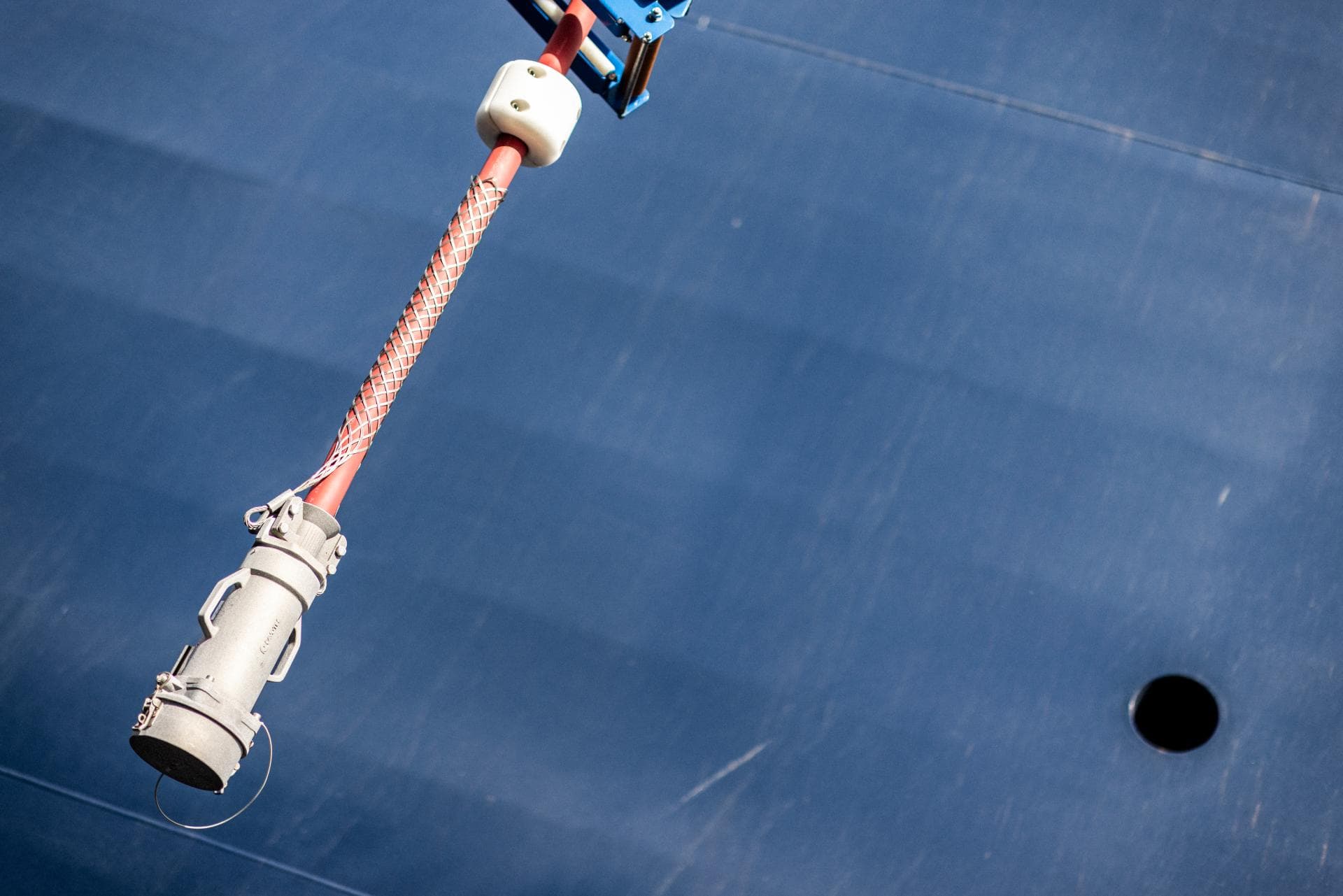 The shore power cable to be seen hanging just beside the side of the ship