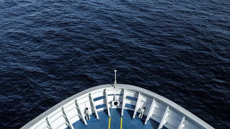 Downward view of the ocean and the bow of a DFDS vessel