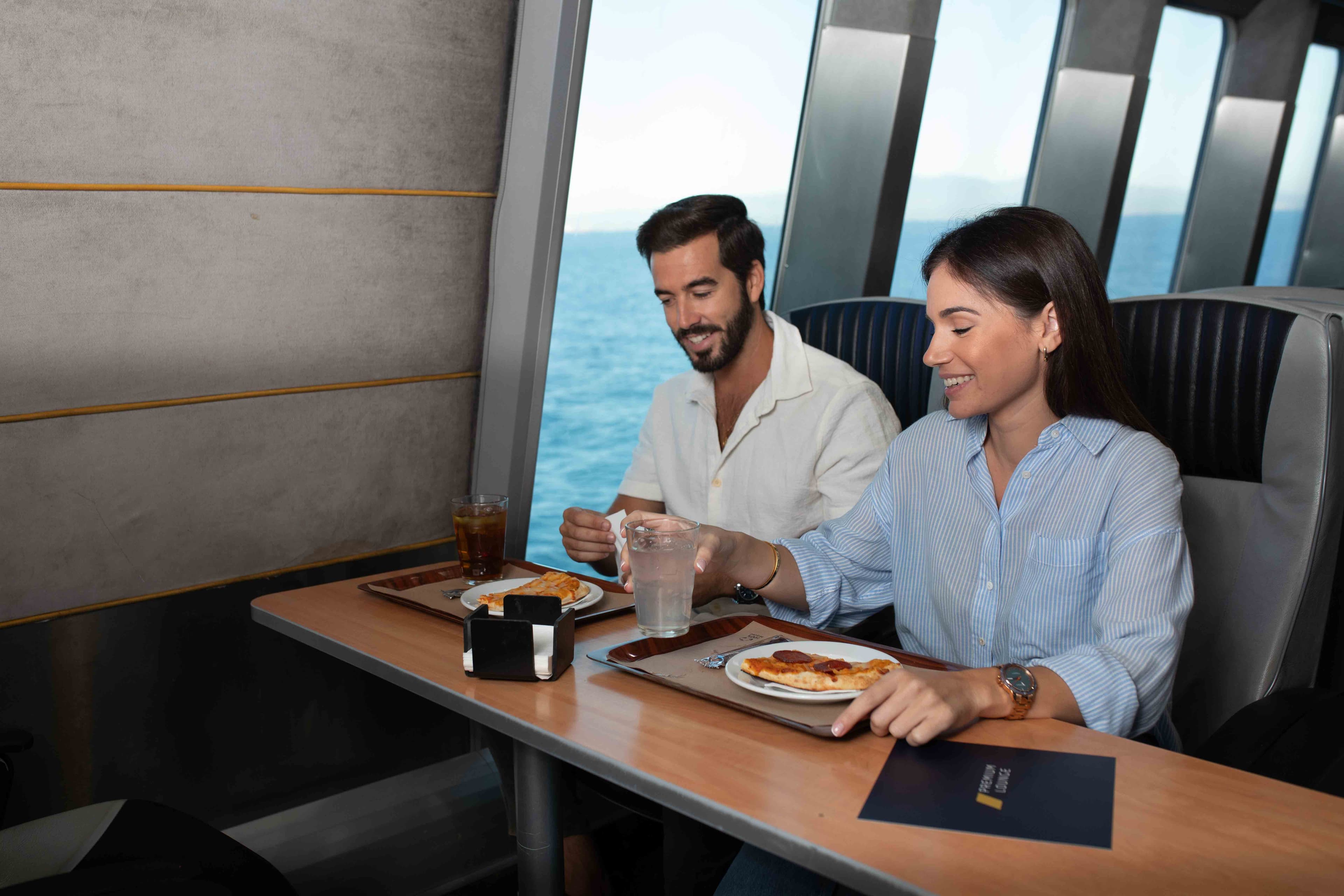 Una pareja disfruta de una comida con vistas al mar en un restaurante.