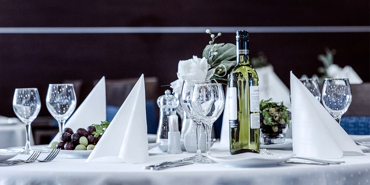 Una mesa con copas y botellas de vino