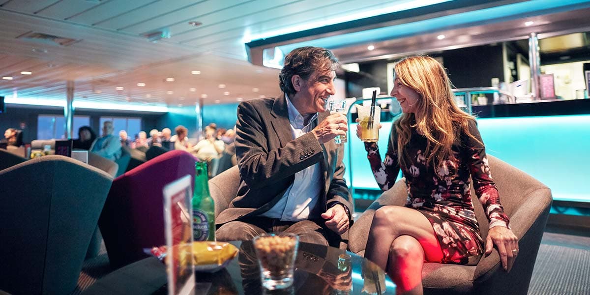Couple enjoying a drink in Columbus Club onboard Newcastle-Amsterdam