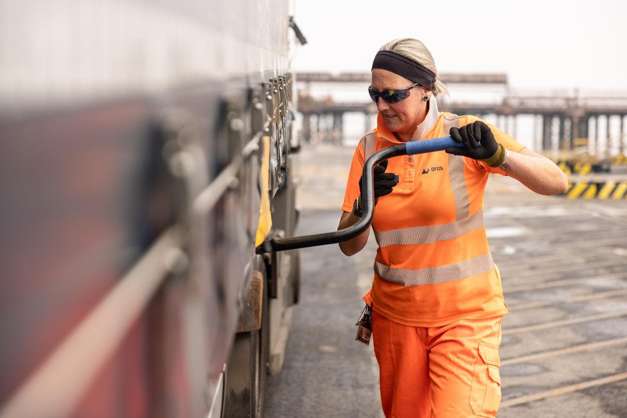 DFDS Logistics employee securing tie-downs on a truck